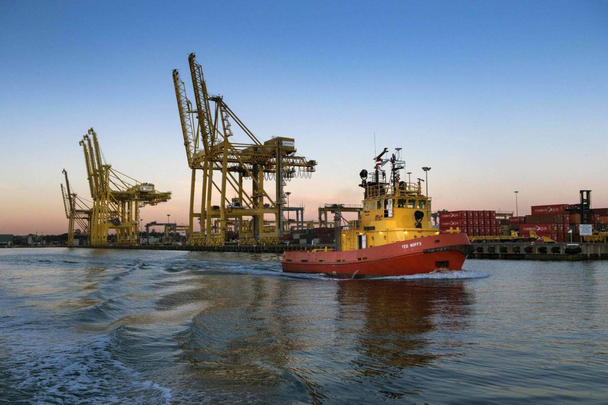 Image of a port and a departing work boat.
